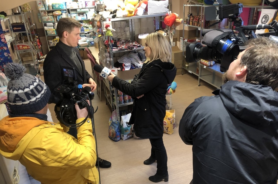 a man is giving an interview to a television crew with a camera