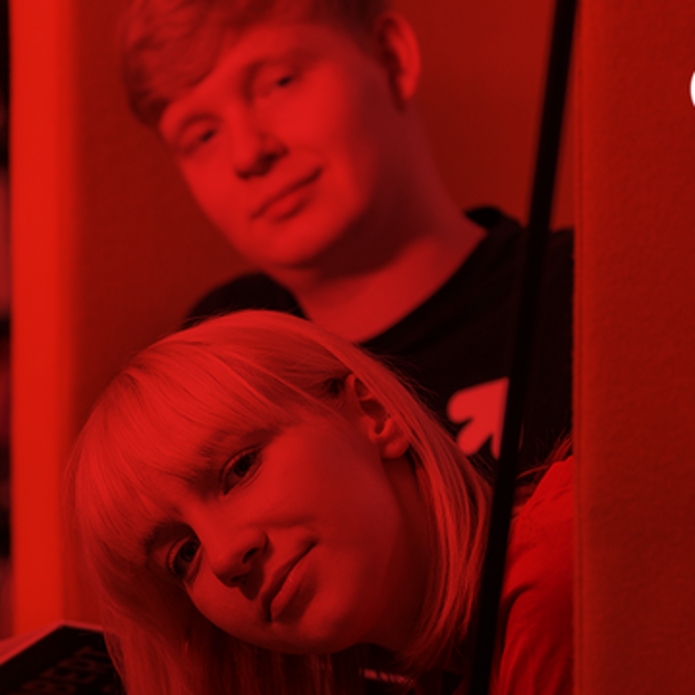A girl and a boy in a library, on a red background
