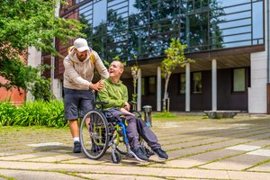 A man with special needs and his friend walking around a university campus. A man with special needs and his friend walking around a university campus.