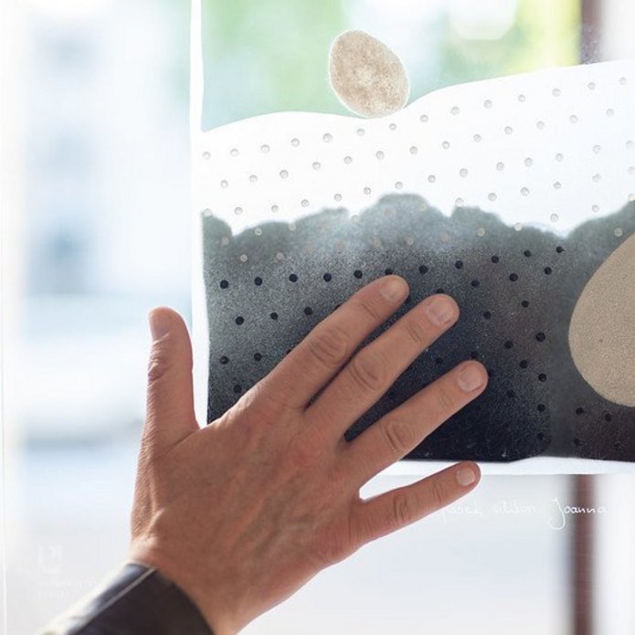 dłoń dotykająca pracy plastycznej na szkle