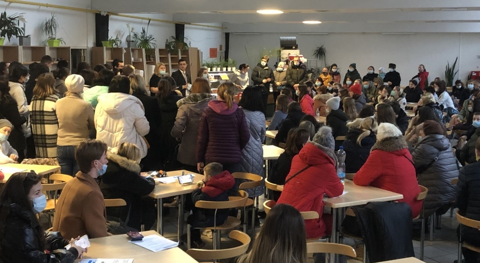 a crowd of people in jackets in the canteen hall