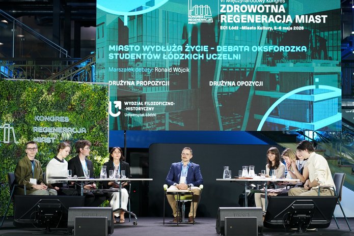 Widok na scenę z debatującymi drużynami w tle duży wyświetlacz konferencyjny