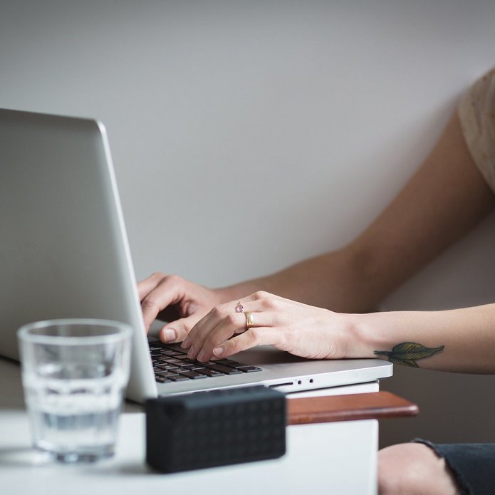 A girl typing on a laptop keyboard