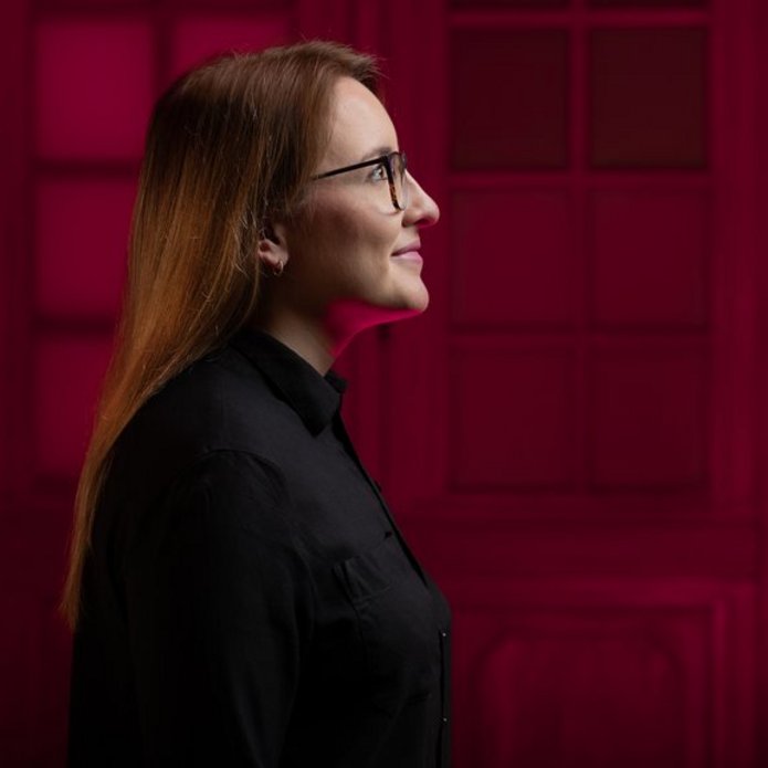 The photo shows the profile of a student on a red background.