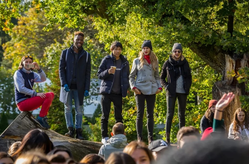A group of young people against a background of green trees