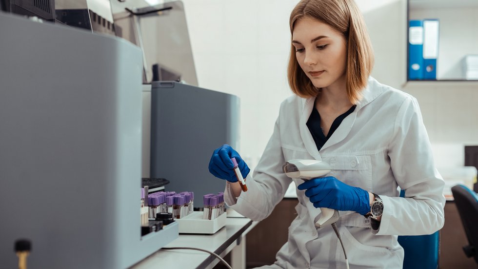 Professional female lab worker holding a test tube with blood Element ozdobny
