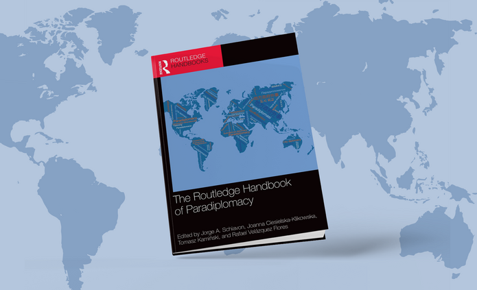 Okładka opisywanego wydawnictwa na tle mapy świata
