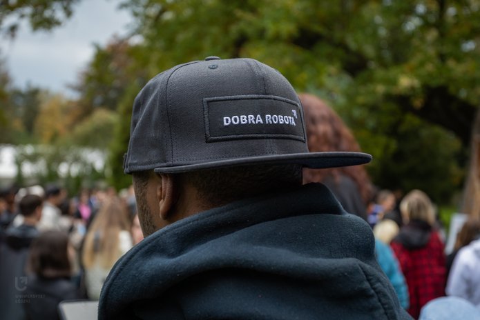 ciemnoskóry mężczyzna z czapką z napisem Dobra robota