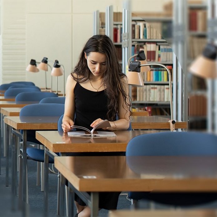 czytelnia biblioteczna, przy stole siedzi dziewczyna