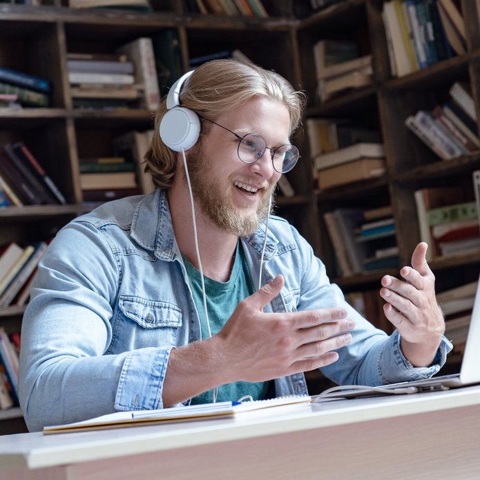 [Translate to English:] plakat ozdobny mężczyzna w słuchawkach mówiący do laptopa