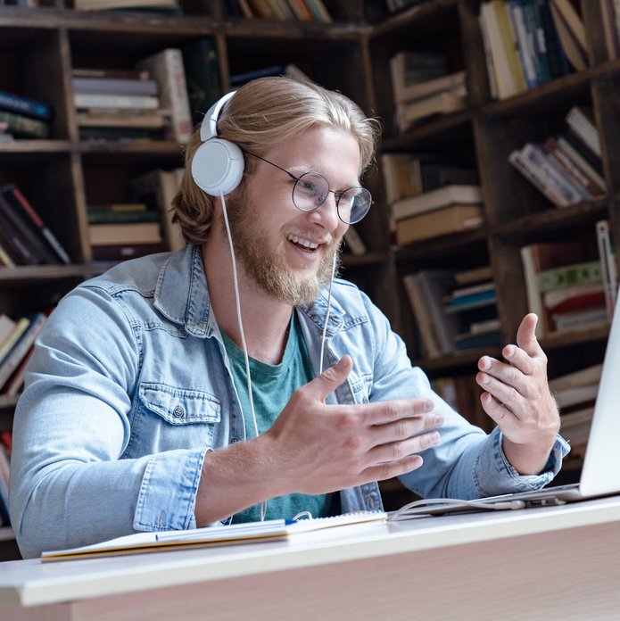 mężczyzna w słuchawkach mówiący do laptopa