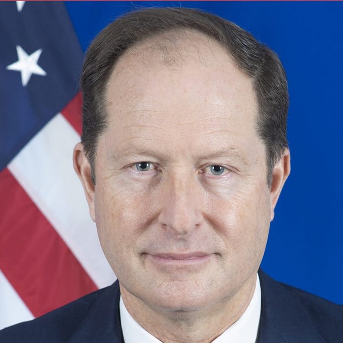 [Translate to English:] plakat informacyjny o wydarzeniu z wizerunkiem Ambasadora Stanów Zjednoczonych Marka Brzezińskiego