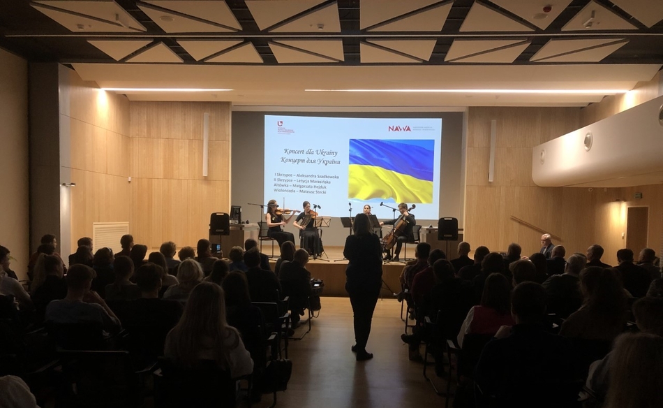 A concert hall filled with audience and string quartet on stage