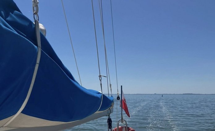 Zdjęcie żagla jachtu podczas rejsu po spokojnej wodzie