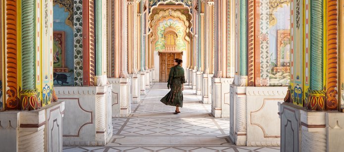A woman walking through the arcades of an Indian building