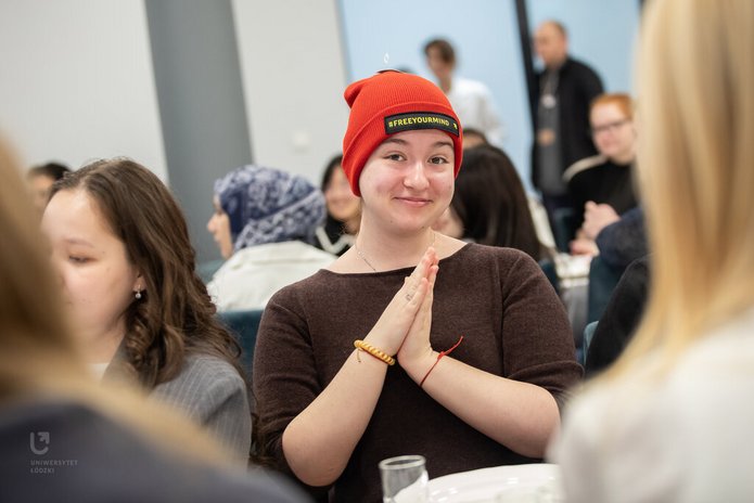 a female student wearing a red University of Lodz cap #freeyourmind