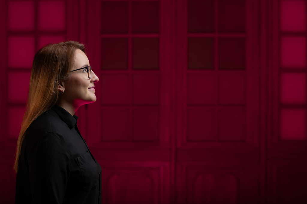 The photo shows the profile of a student on a red background.